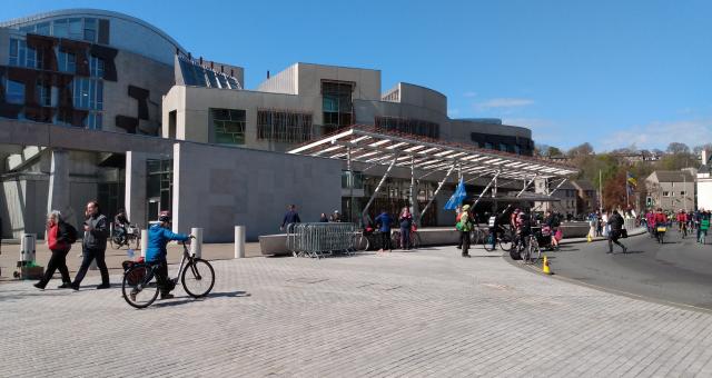 Scottish Parliament Building Holyrood with people walking and cycling outside