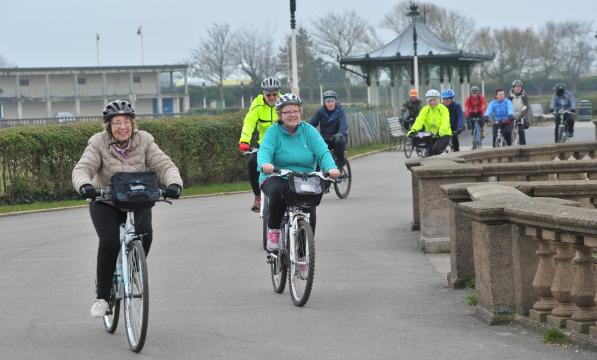 a varied group of people cycling together
